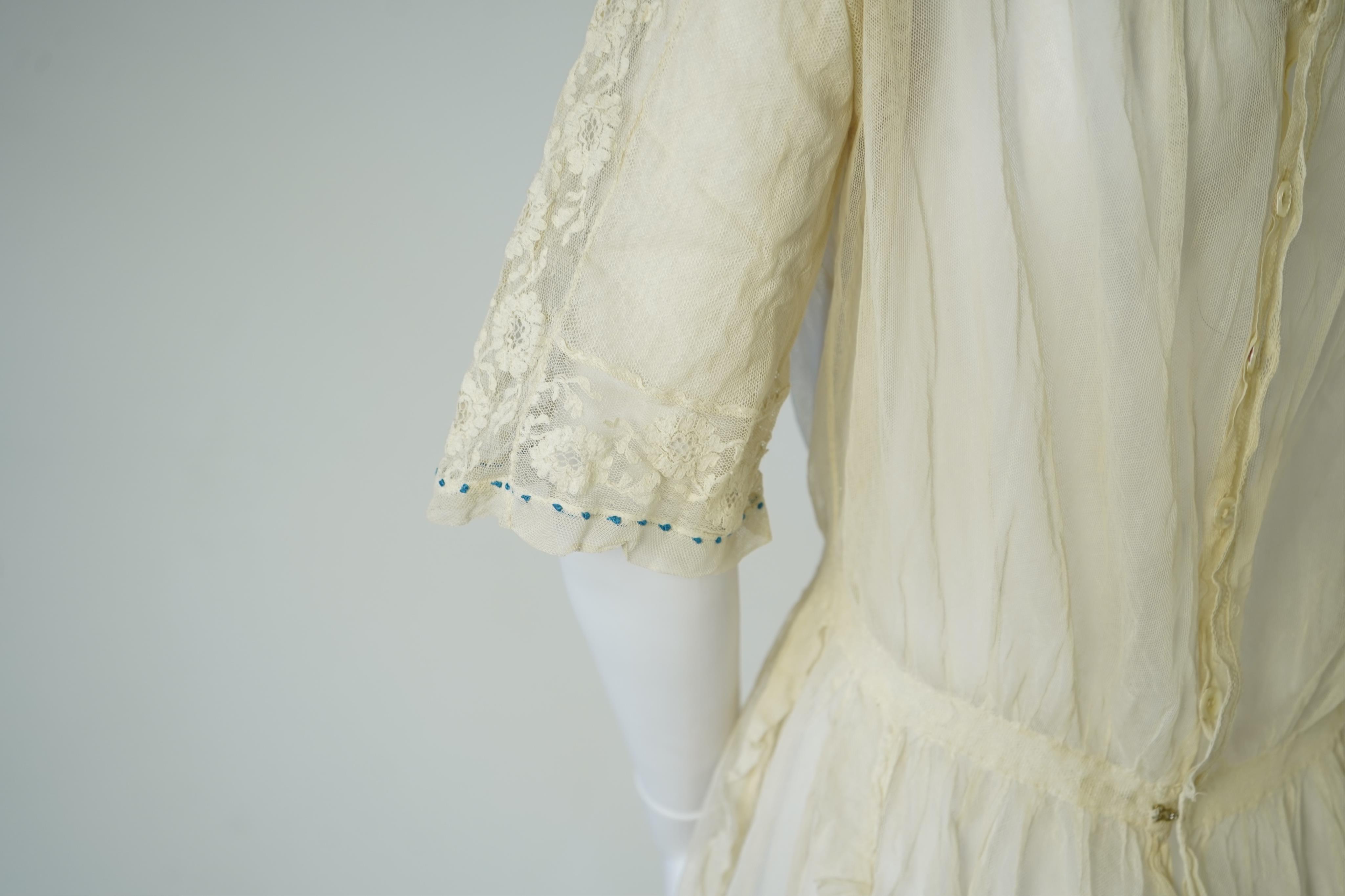 An early 20’s cream net ladies summer dress and net petticoat, designed with a lace inset front skirt, yolk and sleeves.103cm long. Condition - both need re-laundering and some seams tidying.
